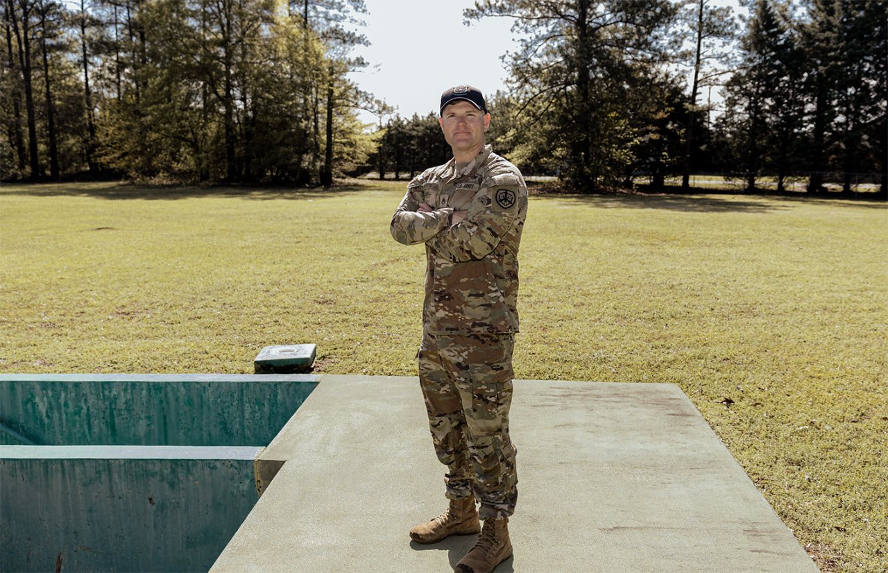 SSG William Hinton standing on a concrete slab with arms crossed.