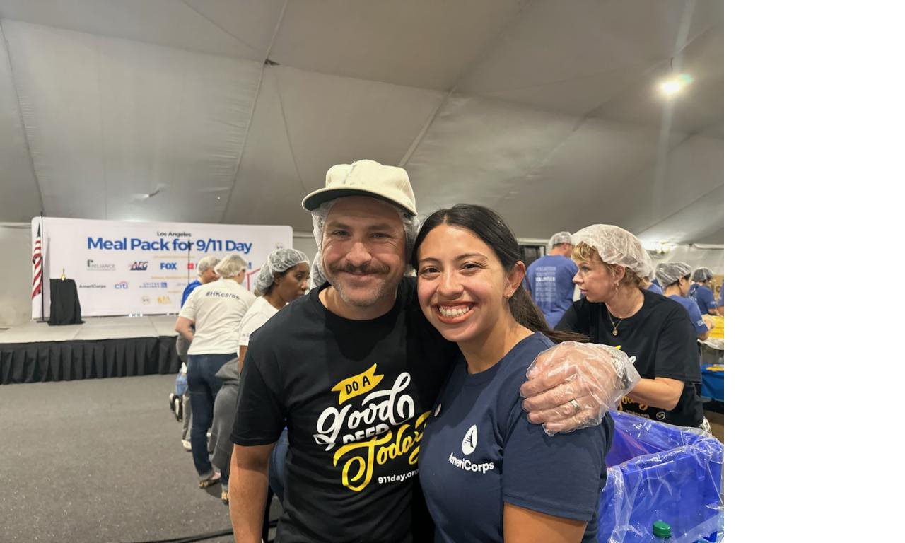 Cait and Kevin smiling at the camera during a 9/11 pack a meal event.