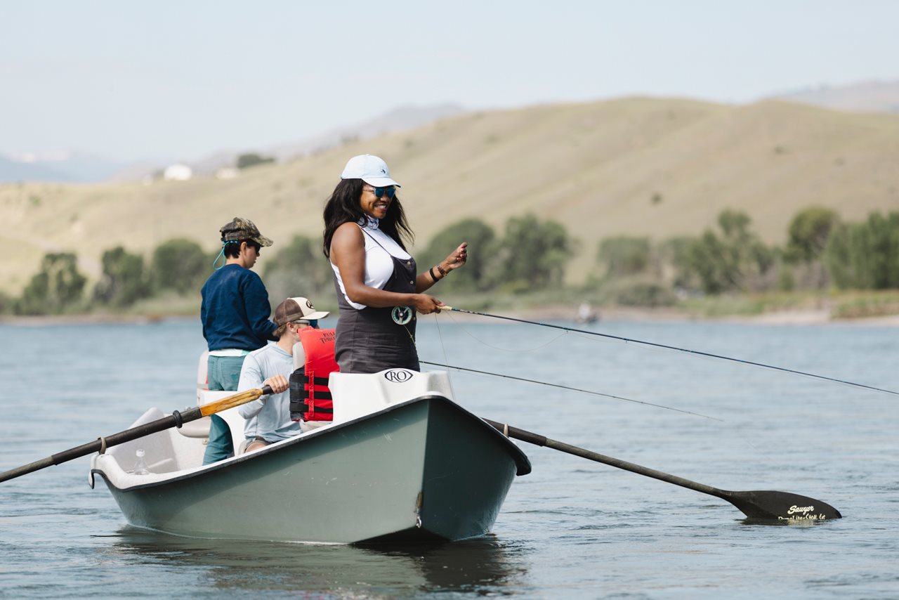 Angelica fishing from a row boat weith two others onboard.