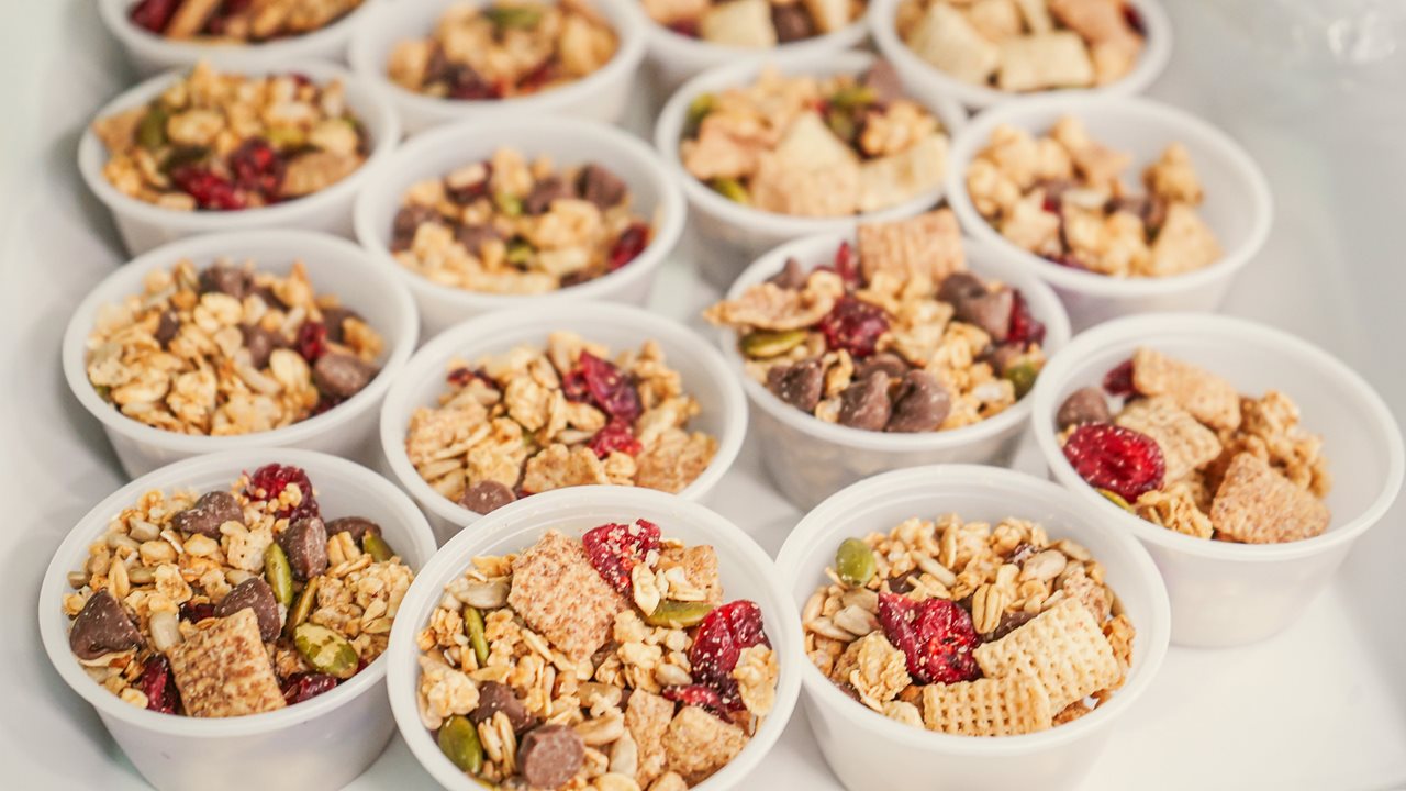 Trail mix in little cups on a tray.