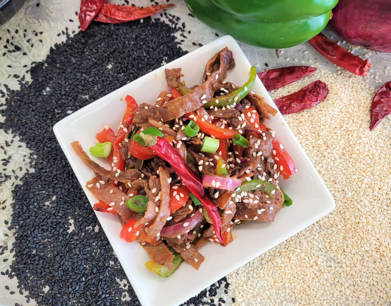 Bowl with meat, peppers and seseame seeds.