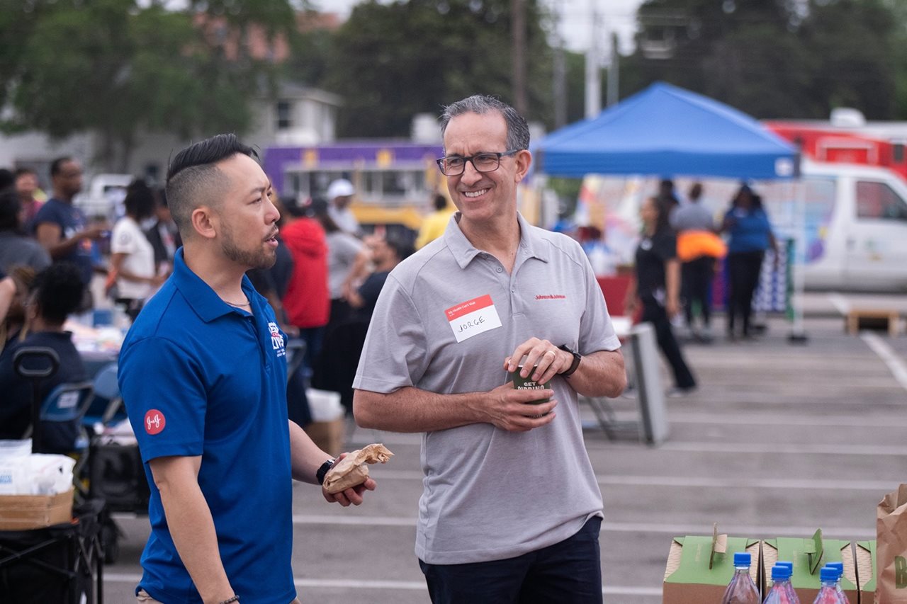 Two men chatting during an outdoor event.