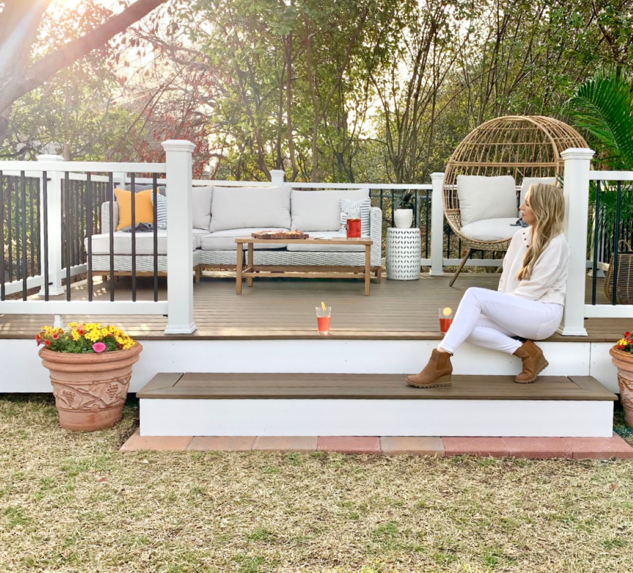 Woman sitting on a step leading to a deck.