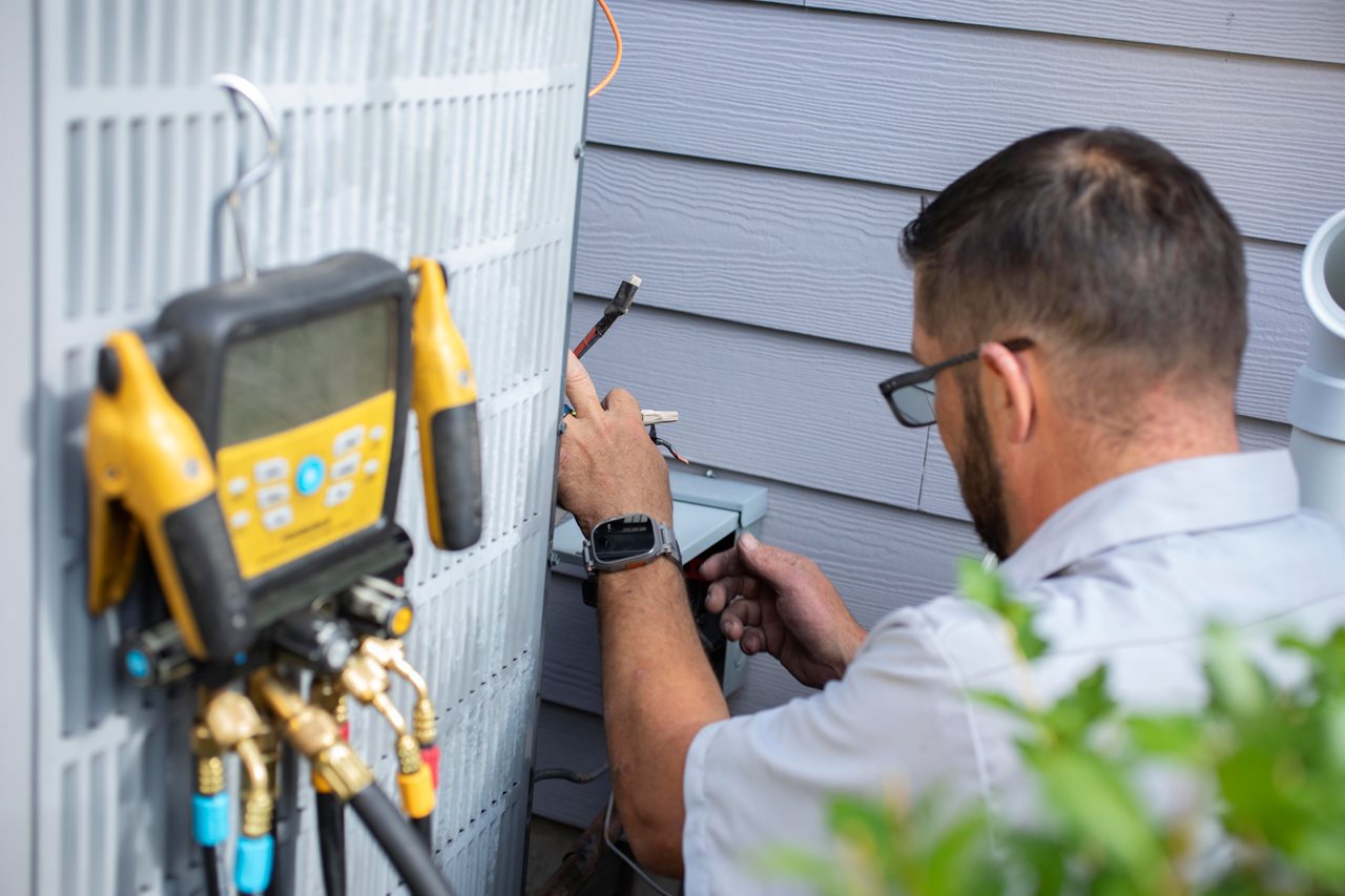 HVAC service person working on heating/air system.