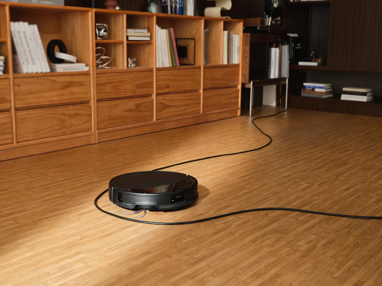 Close up of the Soros 10R cleaning a hardwood floor with an electrical cord laying across it.