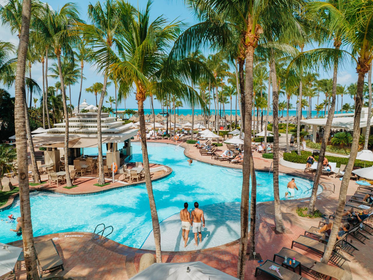 Aruba Mariott  pool area with palm trees and people.