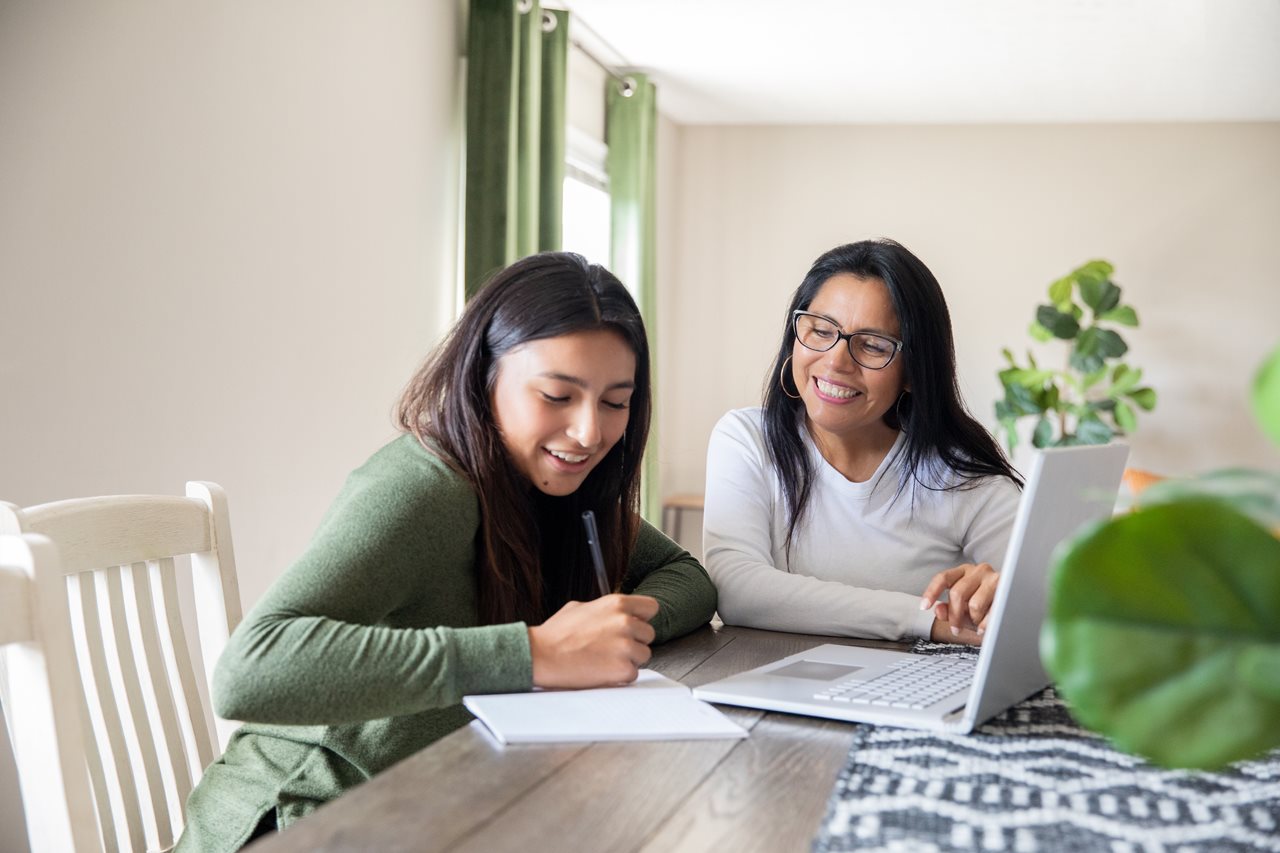 Mom and daughter making a list of possible expenses and things needed for college.