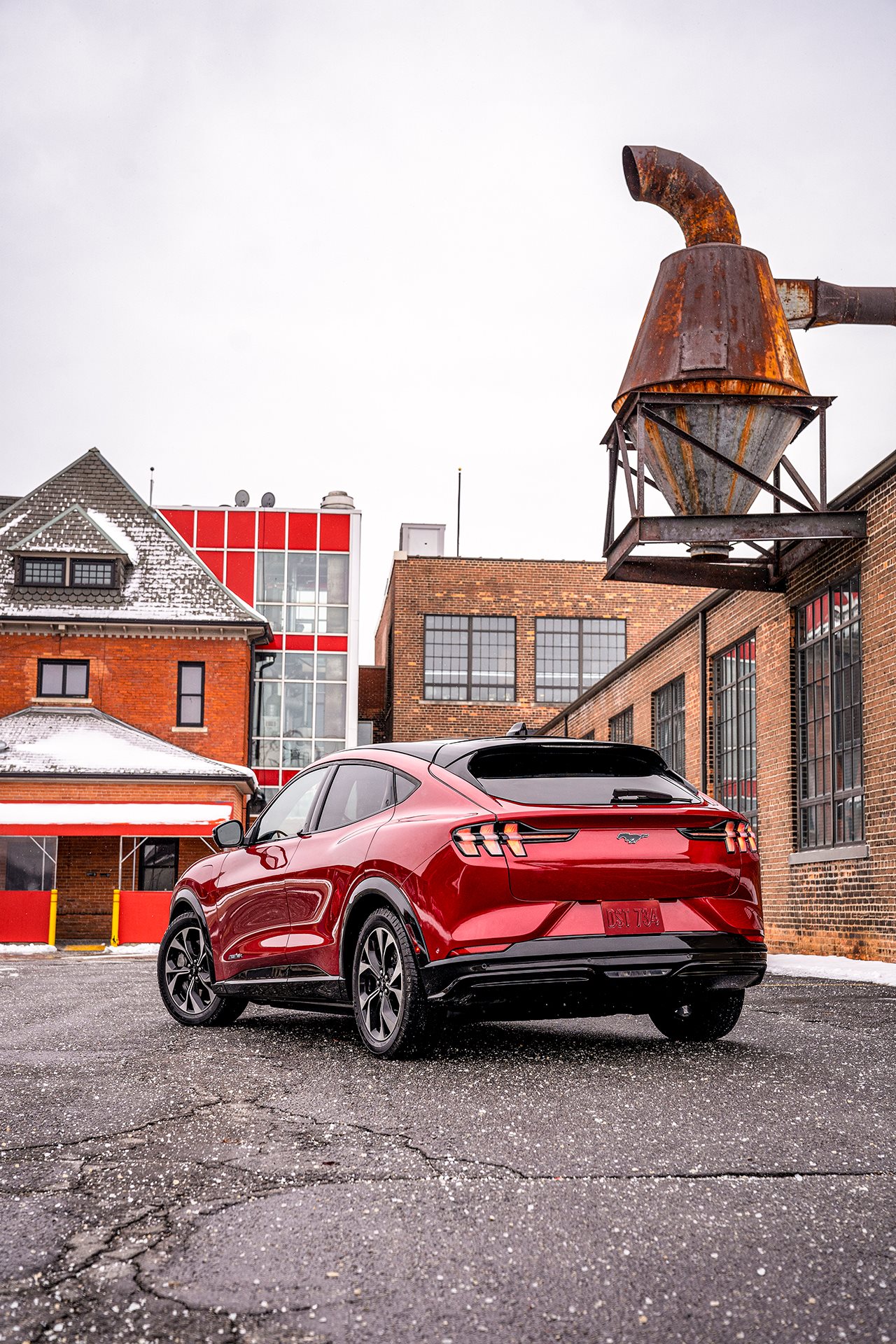 Red mustang on a cobblestone city street.