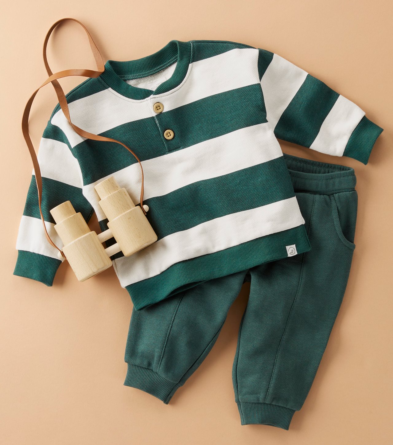 Green and white striped henley with matching green pants with a pair of binoculars near by.