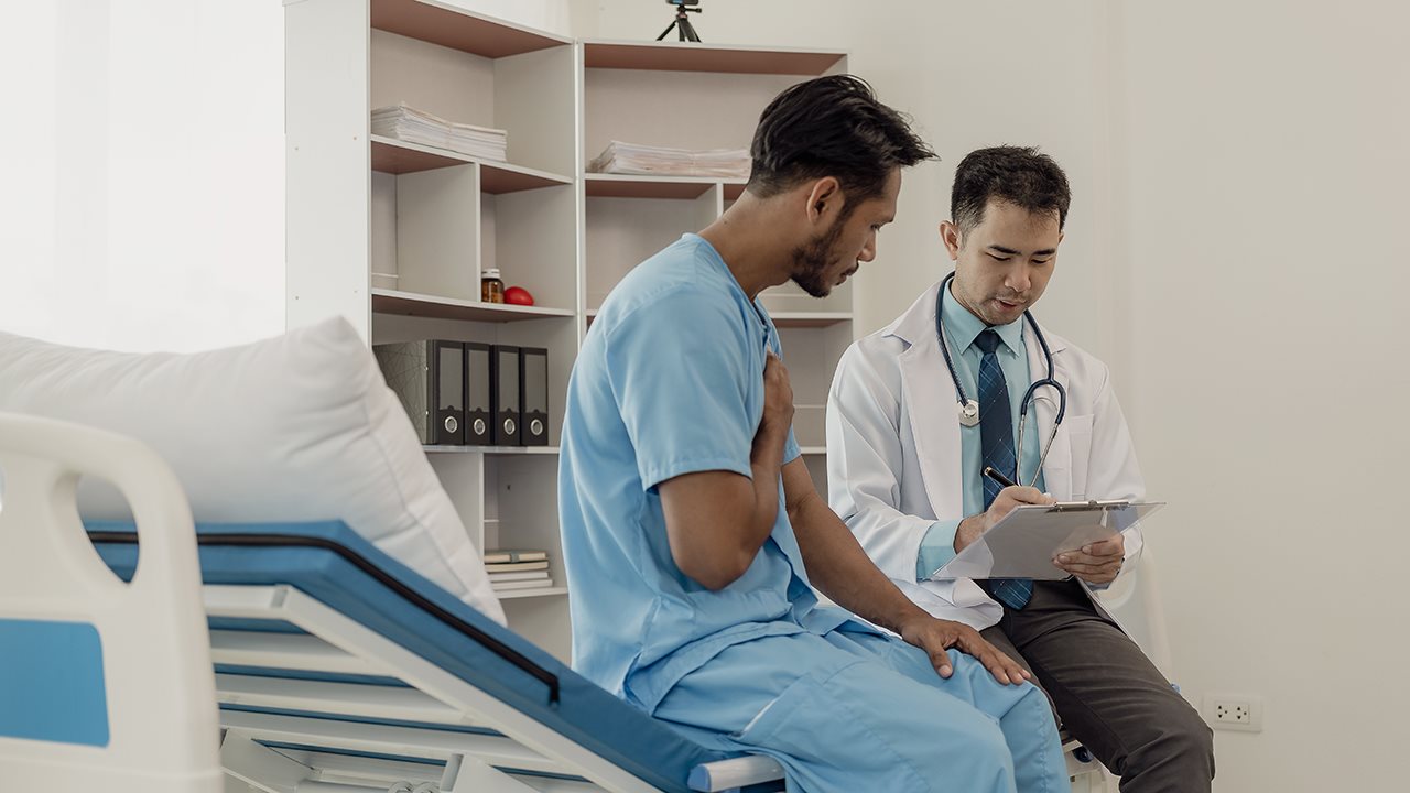 Young male patient talking with doctor in his office.